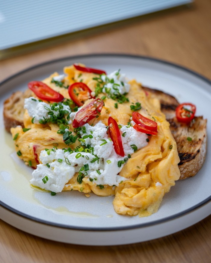 A dish of scrambled eggs with pepper on a muffin at Studley Park Boathouse